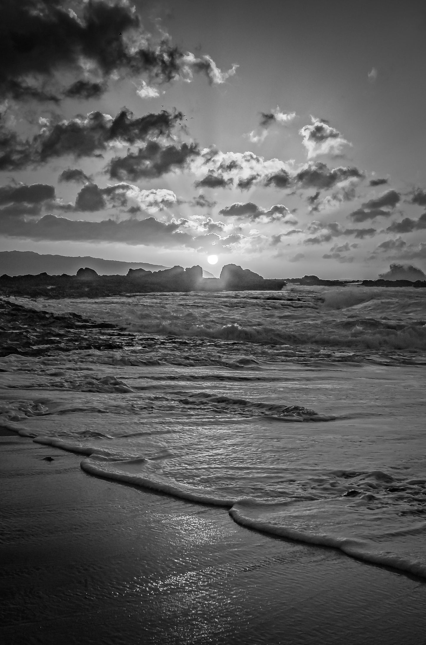 xw Keikis Beach sunset in black and white as the ocean glides in on the North Shore of Oahu